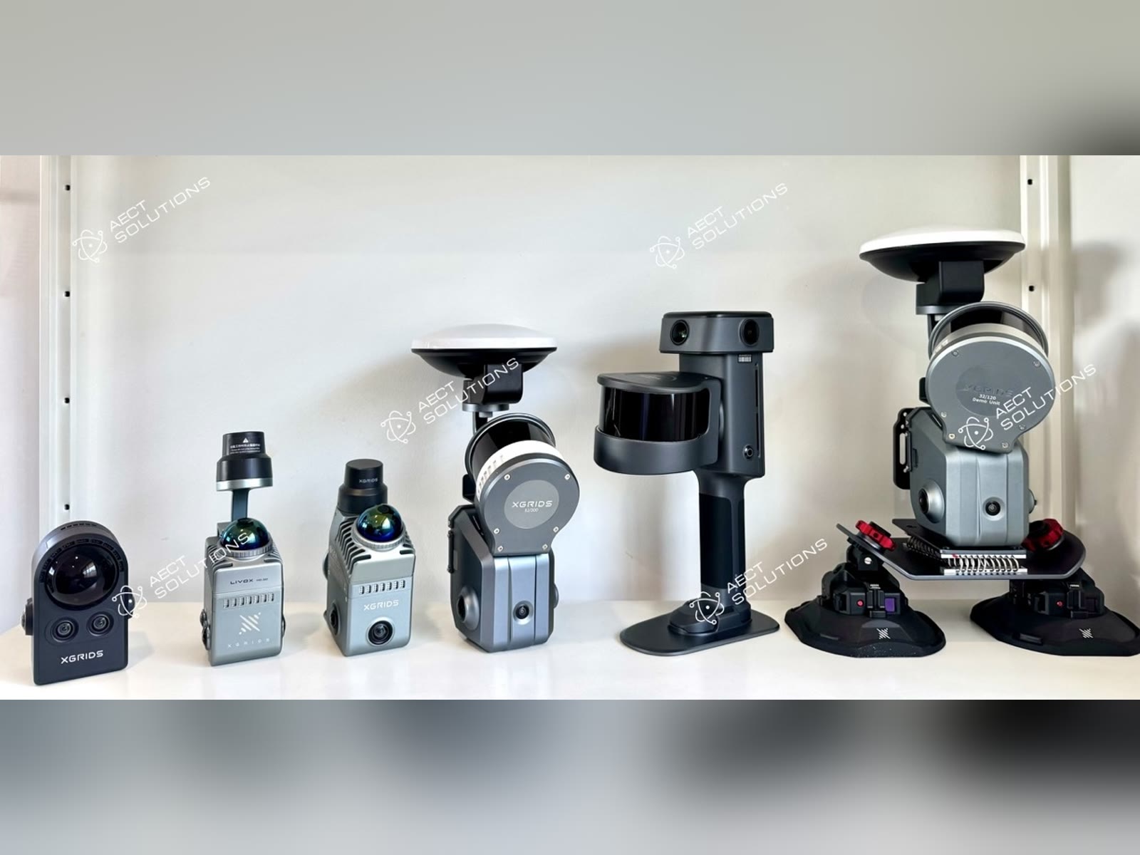 AECT Solutions' XGRIDS demo fleet on a shelf: PortalCam, Lixel K1, Lixel K2, Lixel L2 Pro with RTK, Lixel L3, and an L2 Pro on a vehicle suction mount with RTK