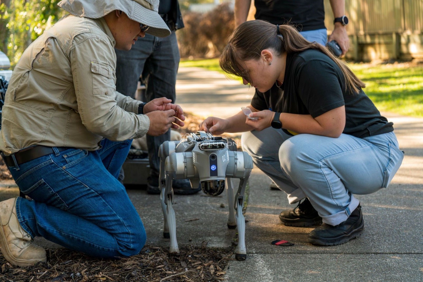 Research team preparing a quadruped robot for a scanning mission
